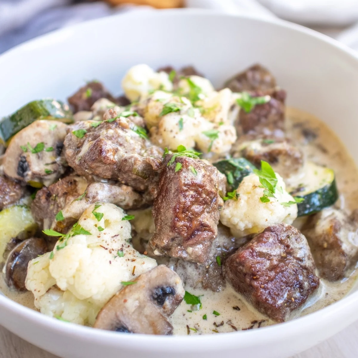 A ladle pouring hearty Cozy Evening Keto Stew into a rustic ceramic bowl for dinner.