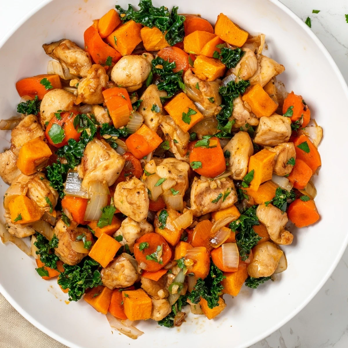 This rustic Snowy Day Paleo Skillet serves four hearty portions, featuring vibrant orange carrots and green kale against the dark skillet surface.