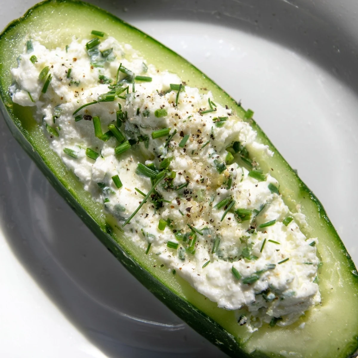 Close-up of Cottage Cheese Ranch Cucumber Boats garnished with chives and dill, perfect as a refreshing gluten-free snack.