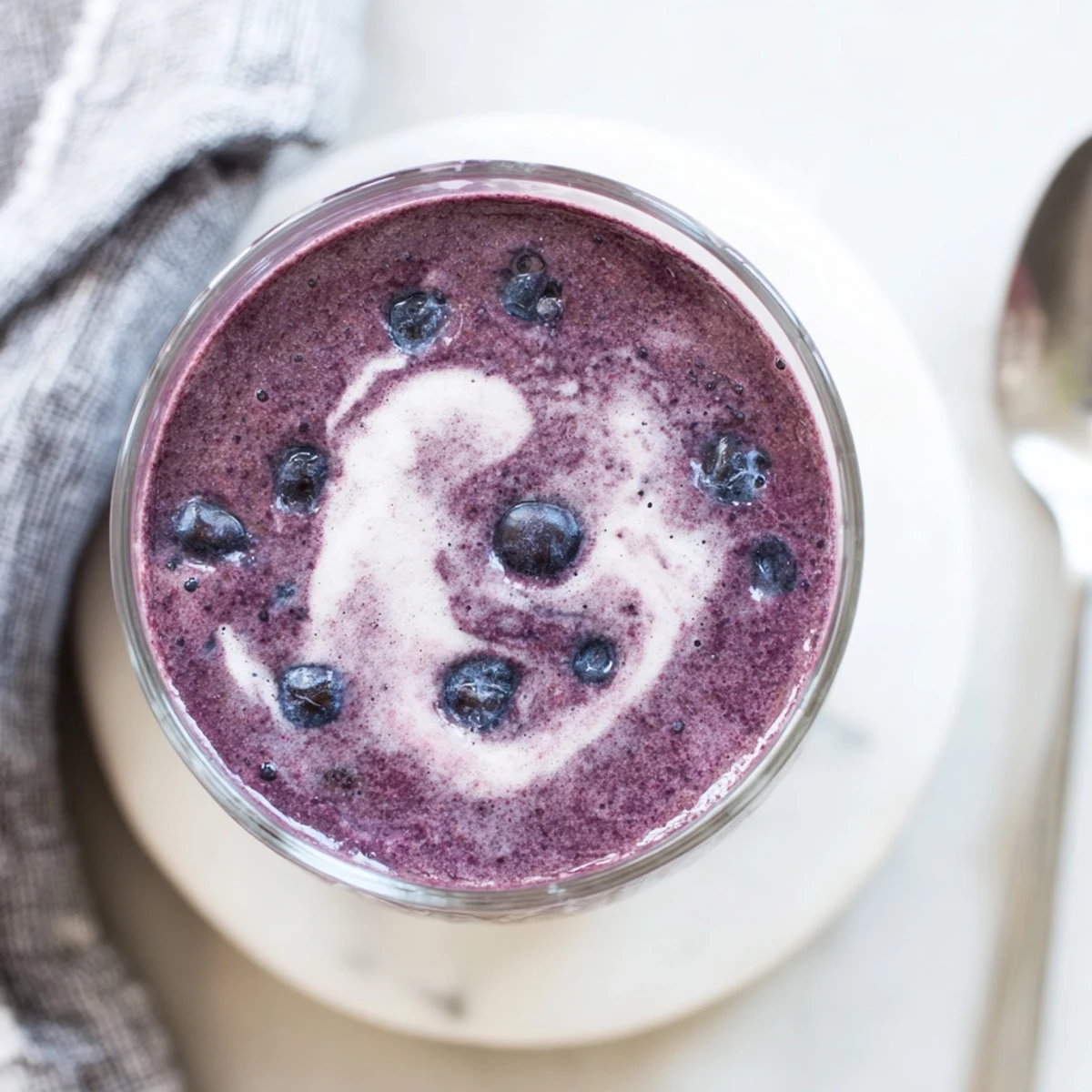 A vibrant glass of blueberry almond butter protein smoothie with chia seeds, perfect for a healthy breakfast.