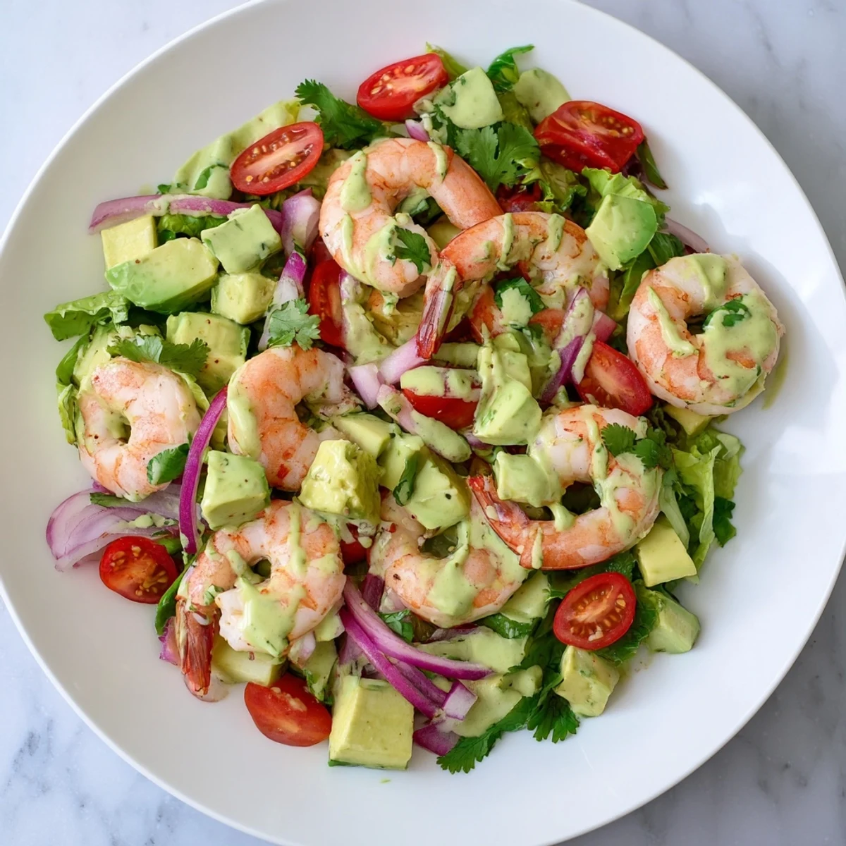 Light and refreshing creamy avocado lime shrimp salad featuring juicy tomatoes, crisp cucumber, and cooked pink shrimp