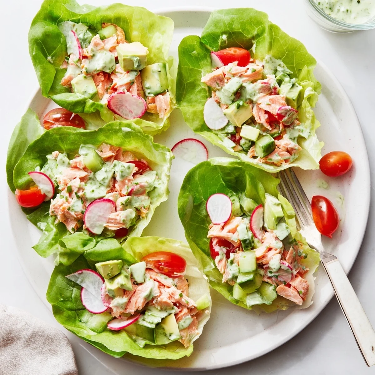 Fresh green goddess salmon salad served in butter lettuce cups with diced vegetables and creamy herbs