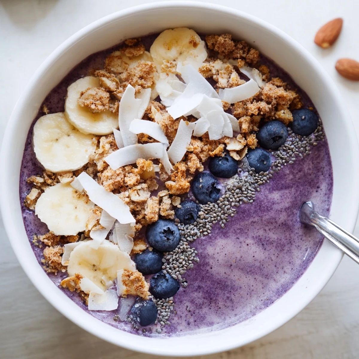 Creamy protein-packed breakfast bowl featuring coconut milk, fresh blueberries and wholesome granola topping
