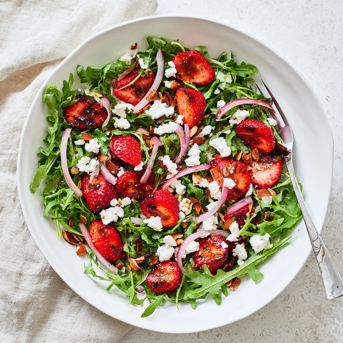 Fresh roasted strawberry and arugula salad topped with tangy goat cheese and crunchy balsamic almonds