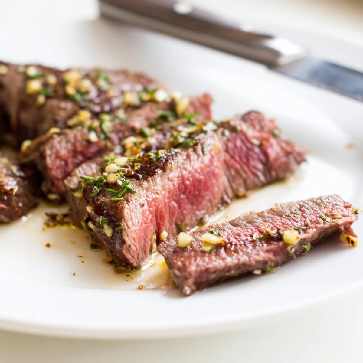 Juicy medium-rare garlic herb steak plated with vibrant spring vegetables, featuring golden roasted carrots, green asparagus spears, and crisp sugar snap peas lightly dressed with lemon.