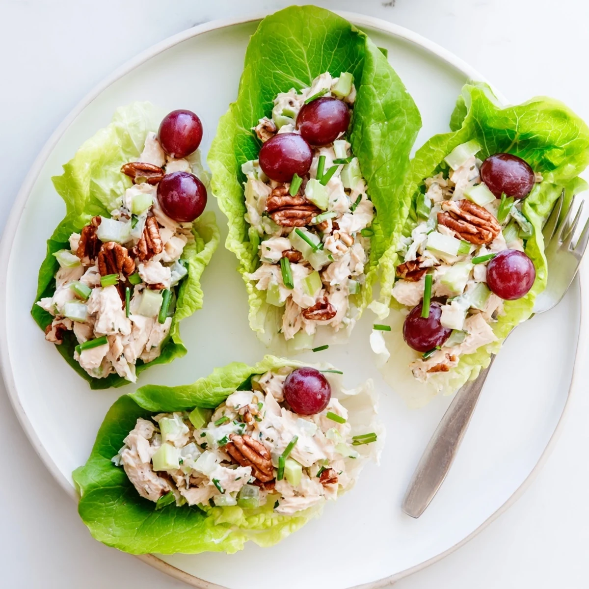 Crisp butter lettuce cups filled with creamy cottage cheese honey mustard chicken salad featuring red grapes and crunchy pecans