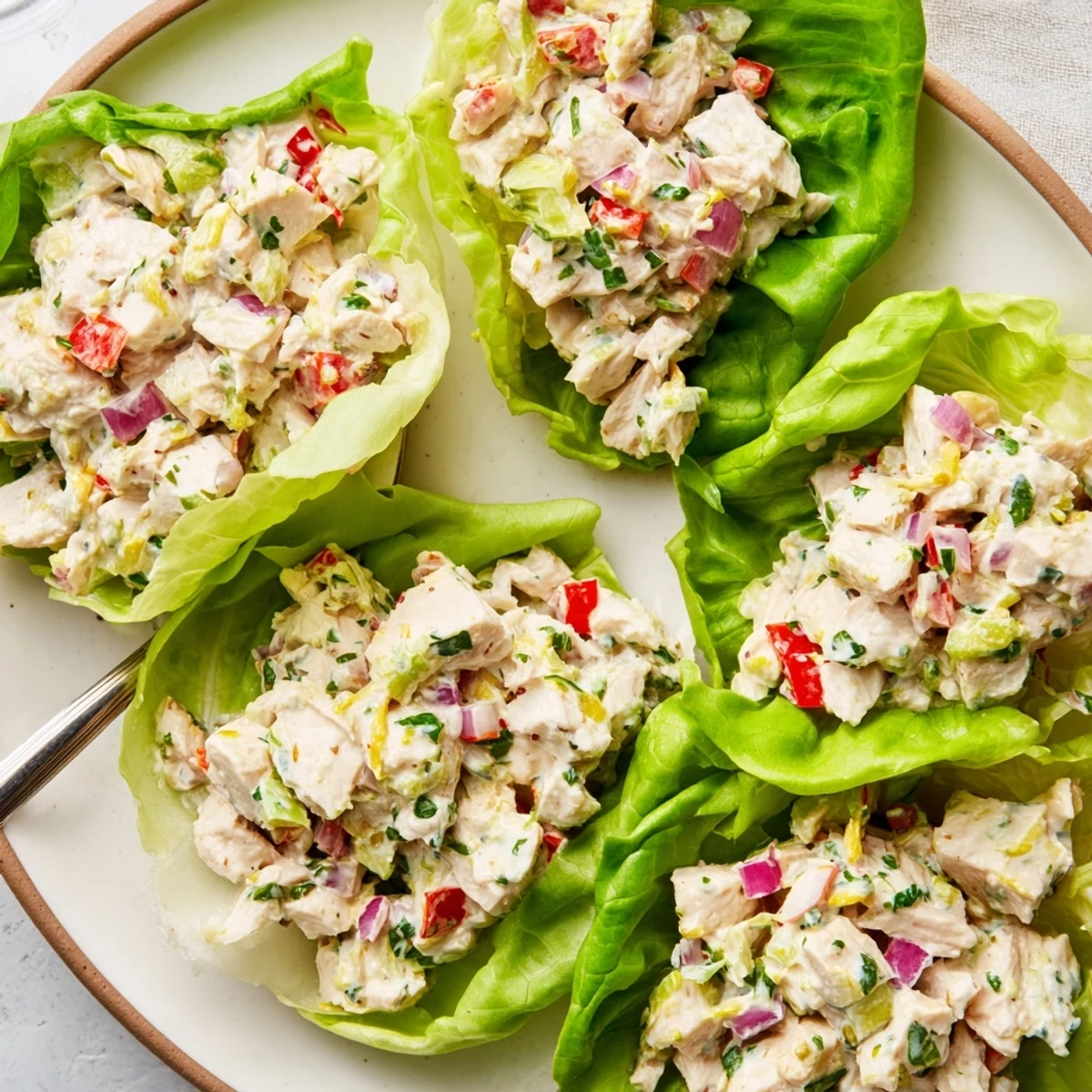Creamy Cottage Cheese Garlic Lemon Chicken Salad Cups spooned into crisp green lettuce leaves