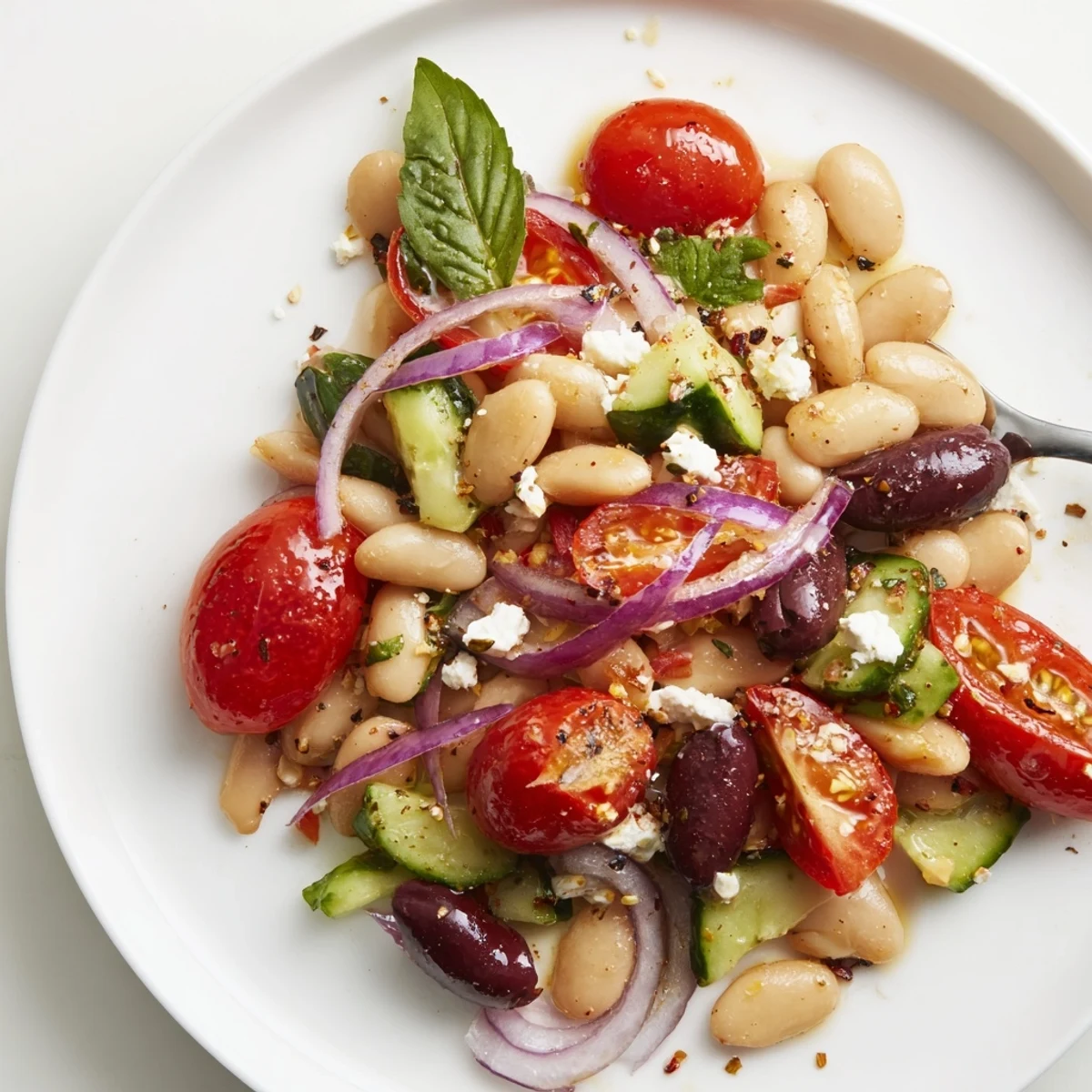 Mediterranean White Bean and Tomato Basil Salad piled with glistening cherry tomatoes, Kalamata olives.