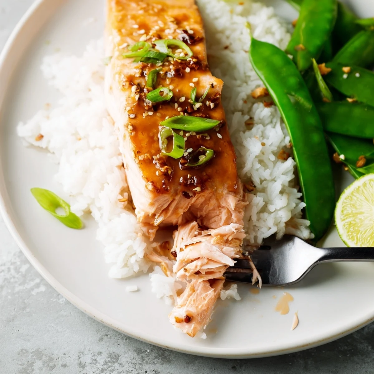 Miso Maple Salmon With Sesame Snap Pea Crunch over steaming rice, scallions.