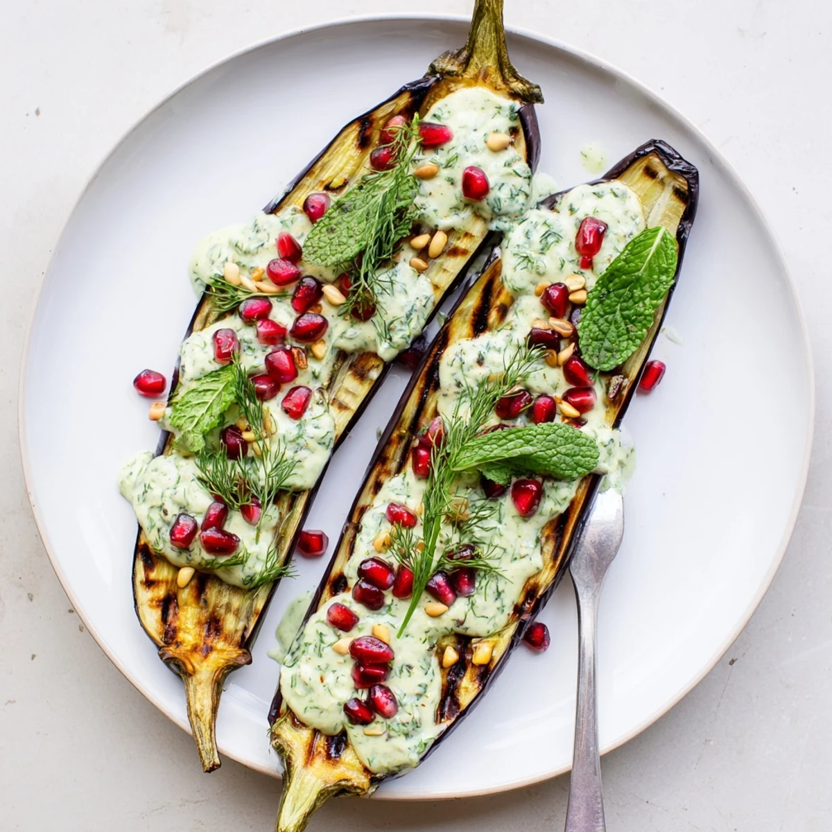 Mediterranean roasted eggplant with velvety lemon tahini sauce served on a white platter