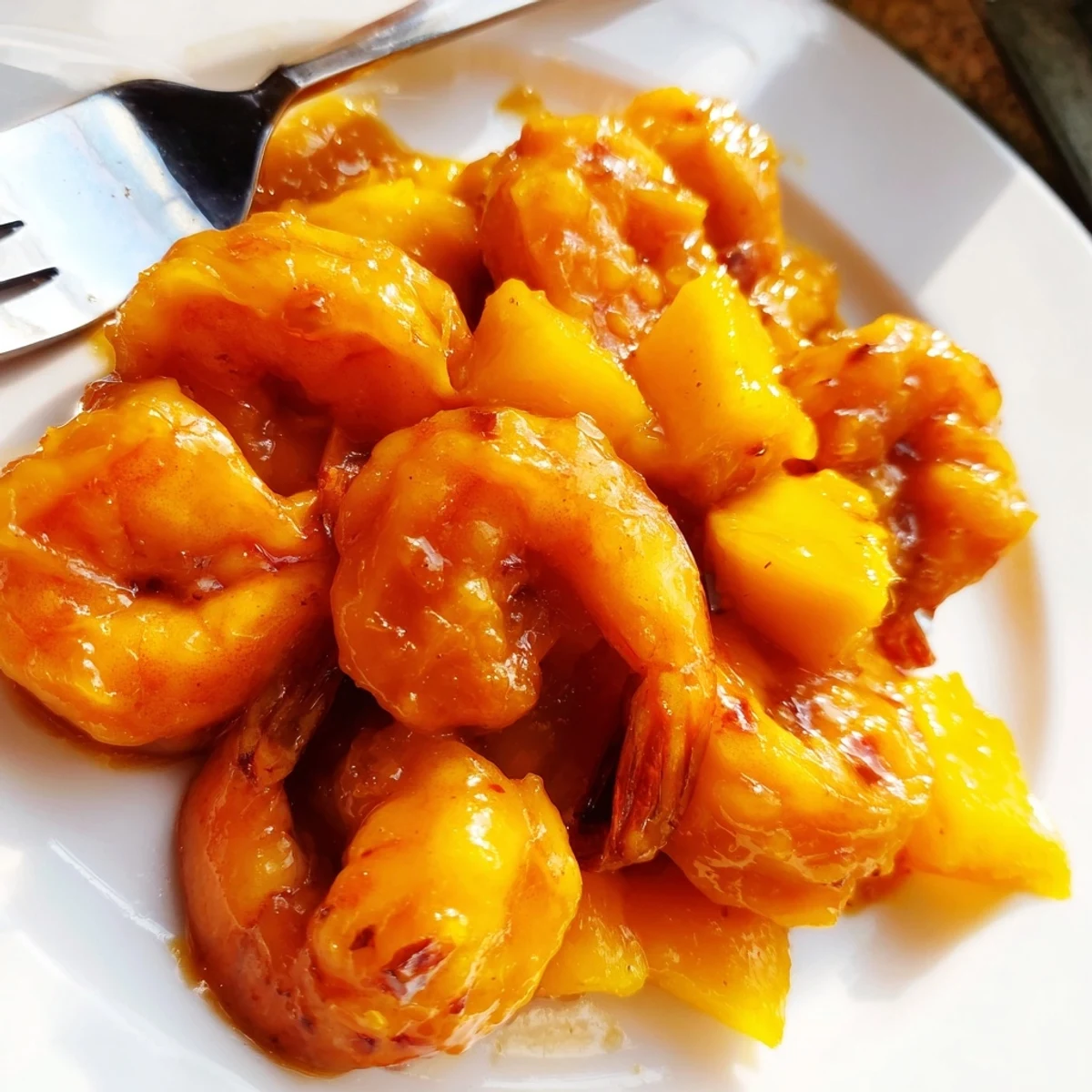 Golden spicy mango shrimp plated over crisp red cabbage slaw with creamy lime avocado dressing and fresh cilantro garnish