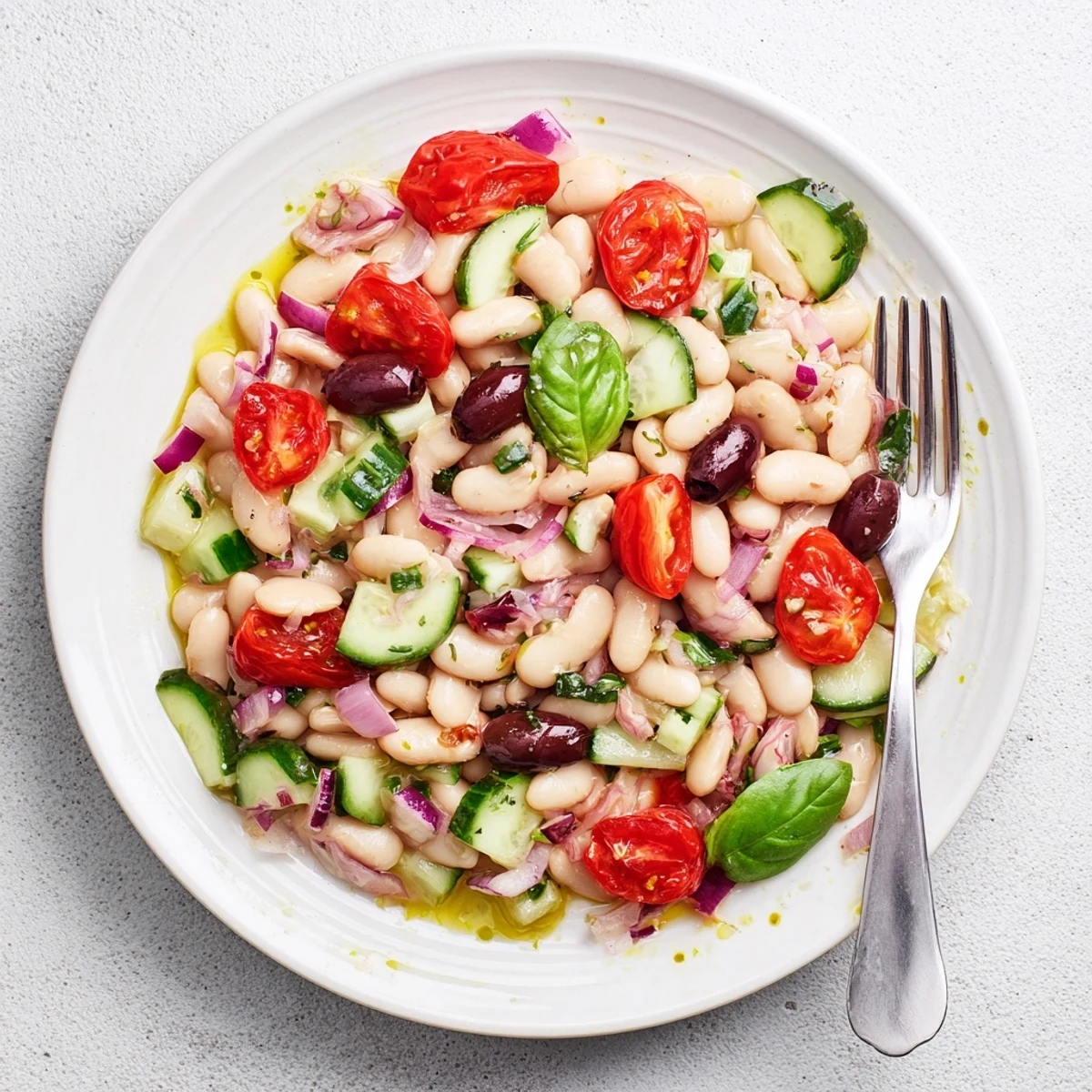 Golden roasted cherry tomatoes nestled among creamy white beans in this Mediterranean white bean and roasted tomato basil salad