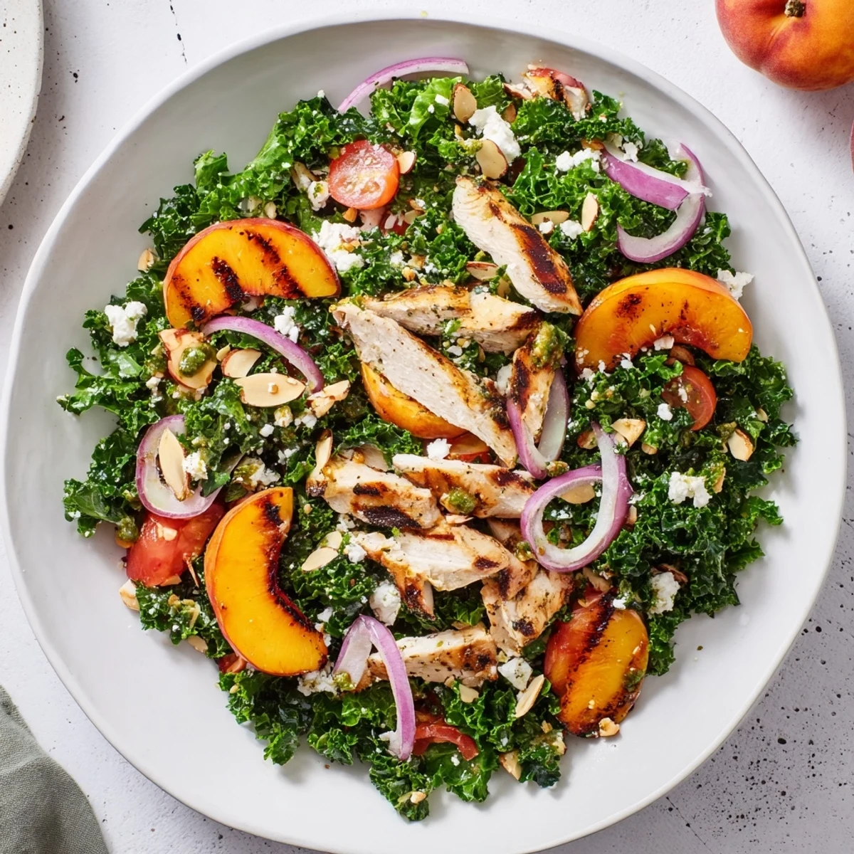 Golden grilled peaches and tender chicken slices over crisp kale with fragrant herb dressing