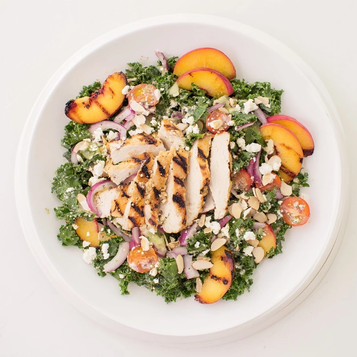 Fresh Grilled Peach and Kale Chicken Salad topped with tangy basil mint vinaigrette and toasted almonds