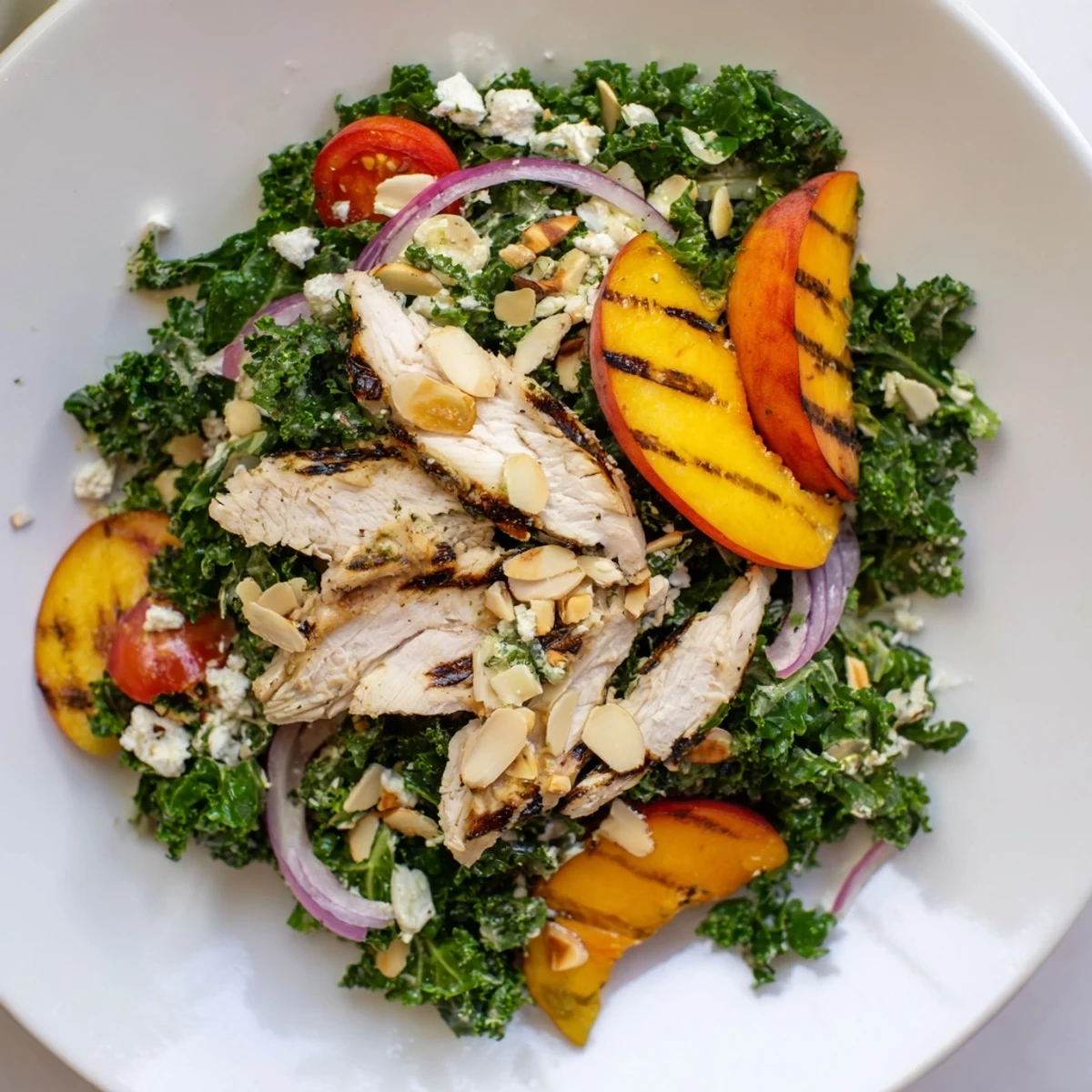 Summer Grilled Peach and Kale Chicken Salad featuring smoky fruit, creamy goat cheese, and fresh greens