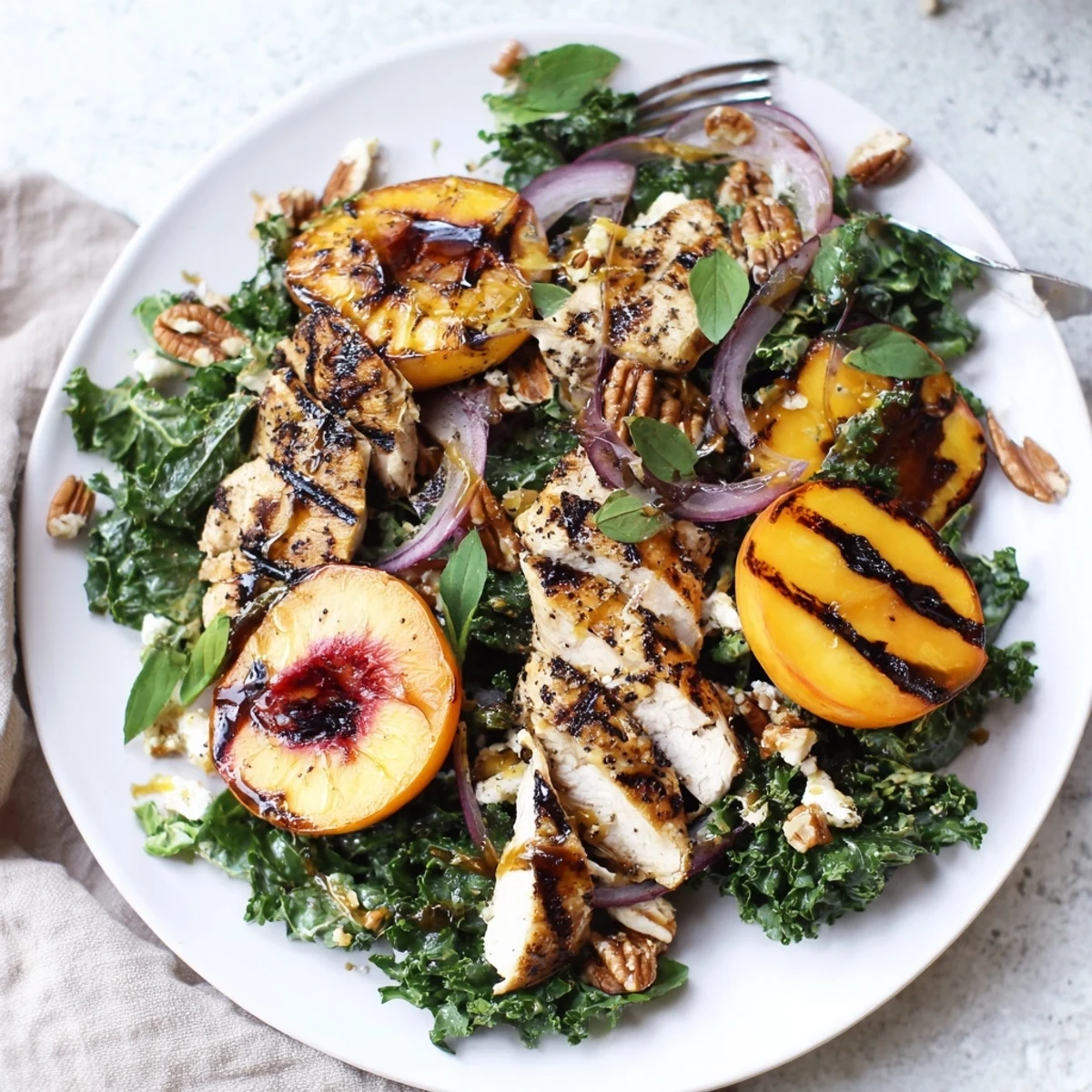 Charred peaches, sliced chicken on Grilled Peach and Kale Chicken Salad with Fresh Basil.