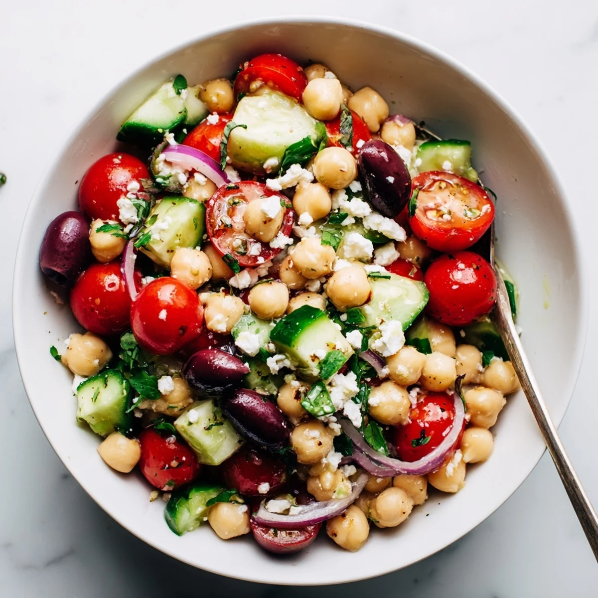 Bowl of Mediterranean Chickpea and Tomato Cucumber Basil Salad, garlicky lemon dressing