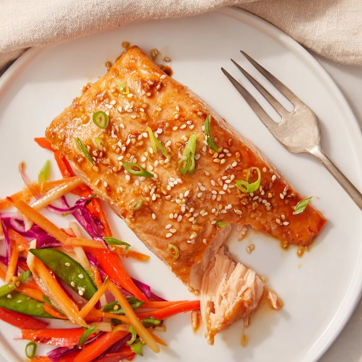 Miso Ginger Salmon With Sesame Snap Pea Slaw plated over brown rice.