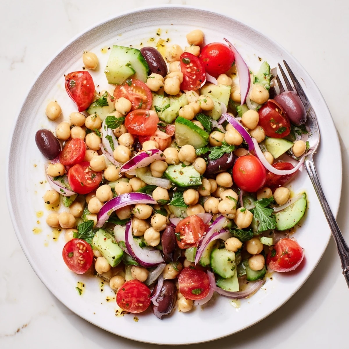 Colorful Mediterranean chickpea salad with ripe tomatoes, cool cucumbers, and fragrant basil leaves