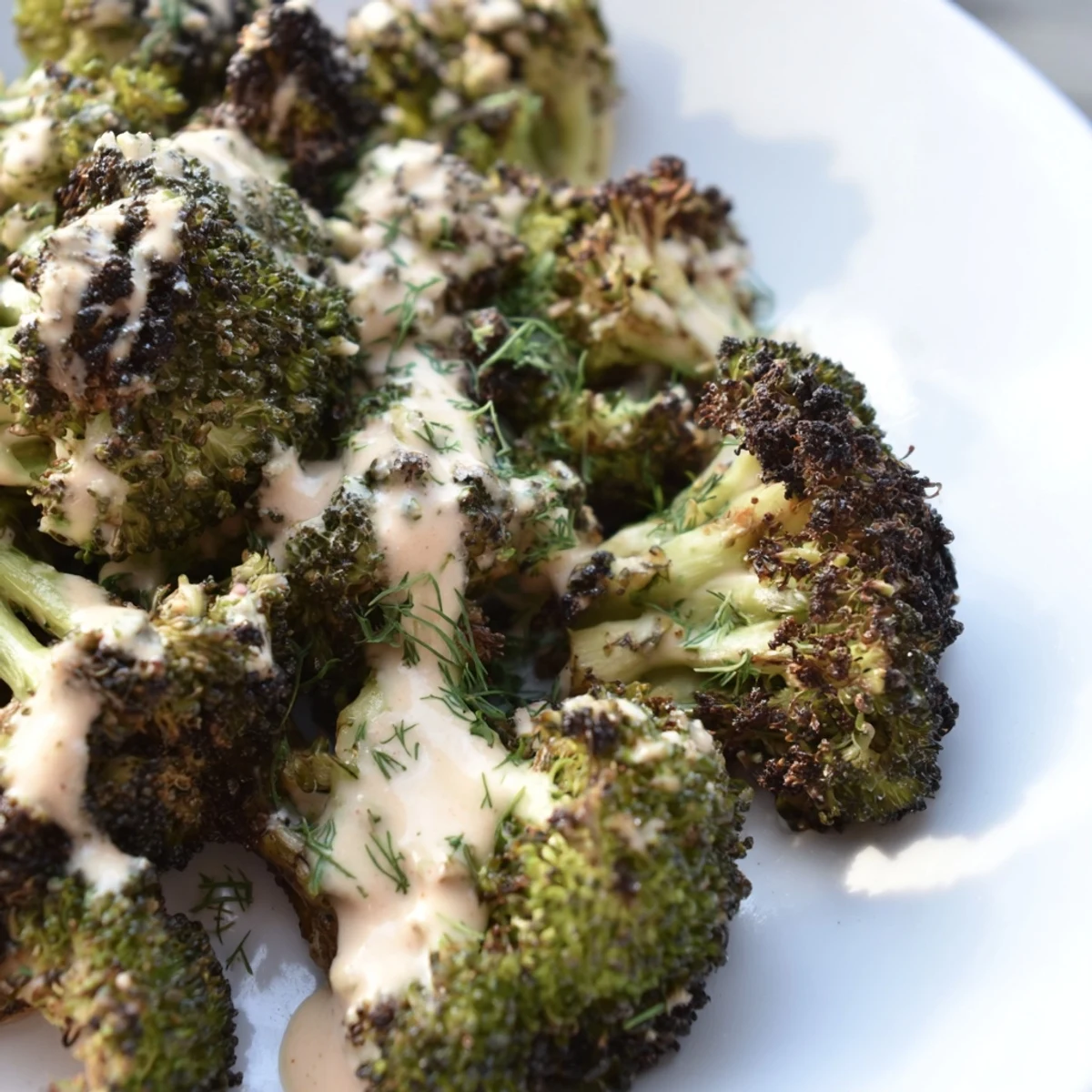 Crispy roasted broccoli with lemon herb tahini drizzle on a rustic serving platter