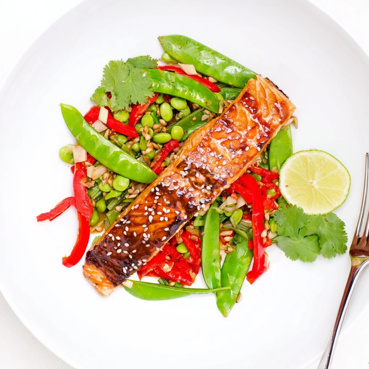 Golden roasted miso ginger salmon fillet resting on a vibrant crunchy sesame snap pea salad