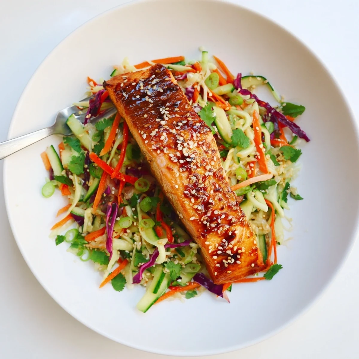 Glazed Miso Ginger Salmon fillets broiled golden and served over crisp sesame cucumber slaw