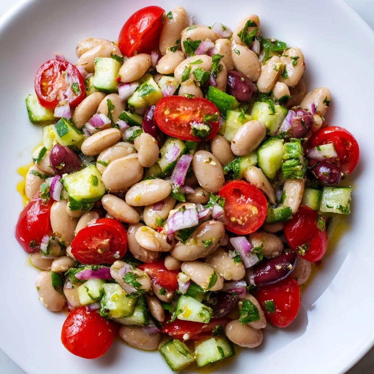 Bright Mediterranean White Bean and Tomato Basil Cucumber Salad topped with crumbled feta and fresh basil leaves