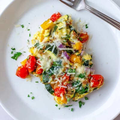 Beautiful Holiday Market Low Carb Frittata, ready to slice, with melted cheese and fresh herbs.