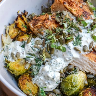 A warm Winter Garden Low Carb Bowl featuring roasted broccoli, cauliflower, and tofu, topped with crunchy pepitas and creamy dressing.
