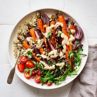 Vibrant Middle Eastern roasted carrot tahini bowl topped with pumpkin seeds and fresh parsley