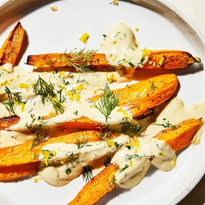 Caramelized roasted carrots topped with creamy lemon tahini herb drizzle and fresh herbs