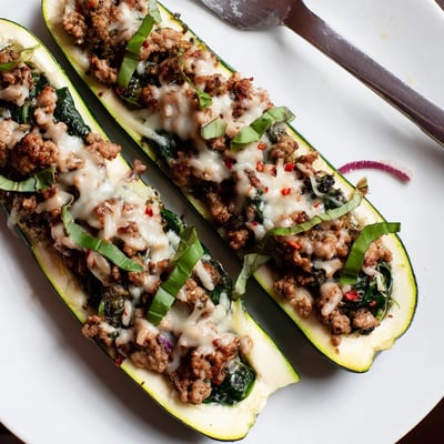 Baked in a dish, Pesto Turkey and Spinach Zucchini Boats with Basil steaming.